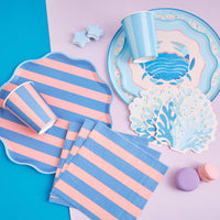 Full Coastal Catch partyware flatlay with crab plate, coral napkins, striped cups