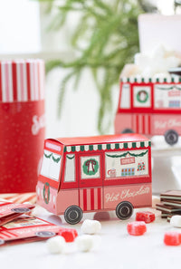 Hot cocoa truck treat boxes styled with a cup of cocoa and holiday props.