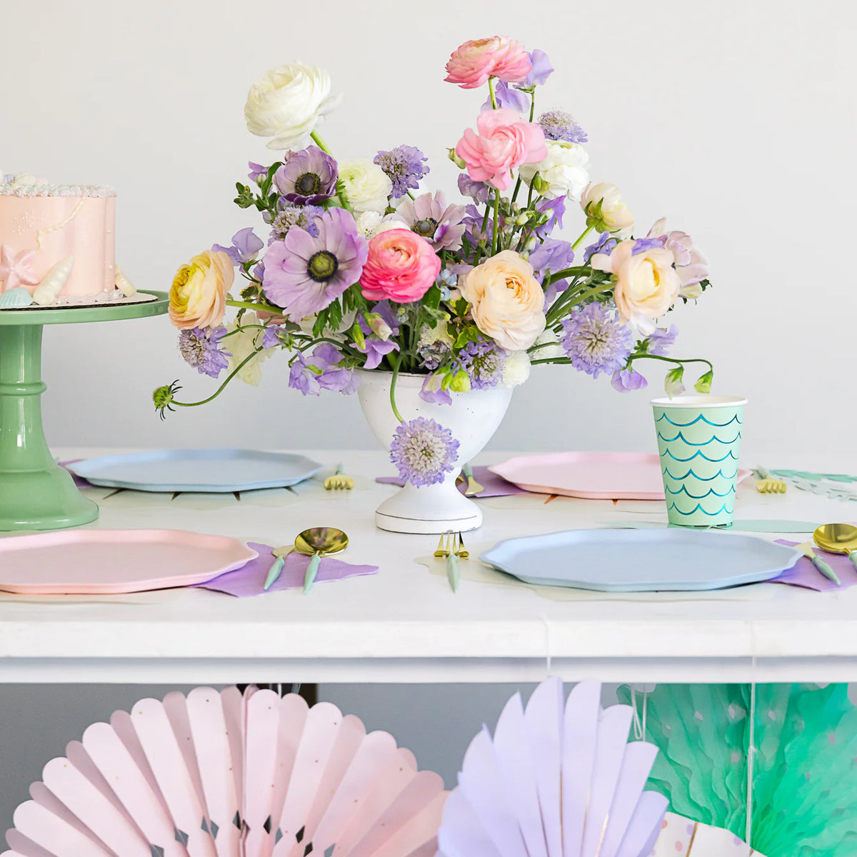 Spring party table with flowers and mixed pastel compostable plates including sky blue.