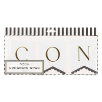 Congrats Grad graduation banner with gold lettering and scalloped white pennants in packaging