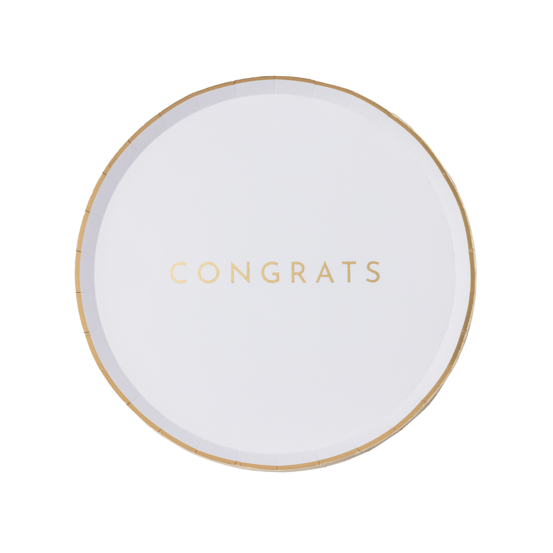Flat-lay white Congrats party plate with gold-foil "Congrats" lettering and a thin gold rim on a clean ground.