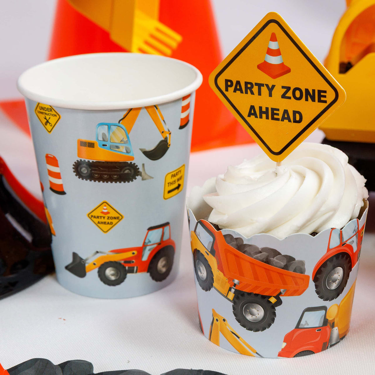 construction party cup next to cupcake with party zone ahead topper