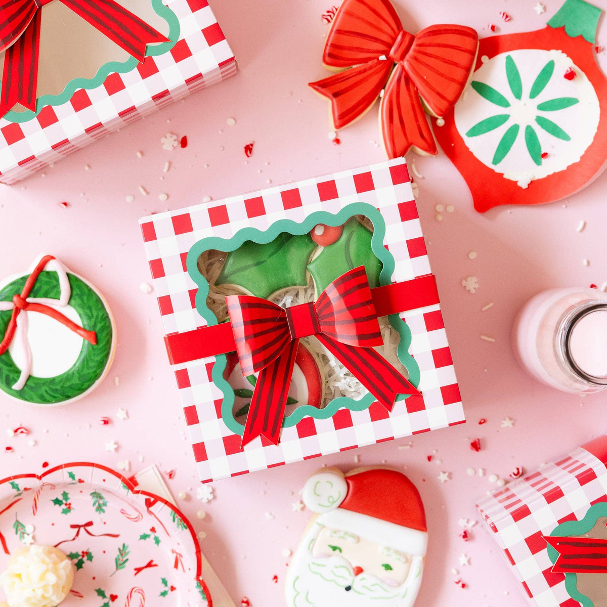 Holiday cookie boxes on pink background with festive cookies