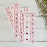 Trio of cherry napkins fanned out on a white wood background
