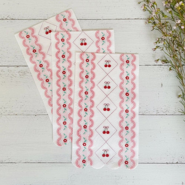 Trio of cherry napkins fanned out on a white wood background