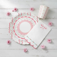 Stacked partyware with a large bow plate, small lace plate, and cup