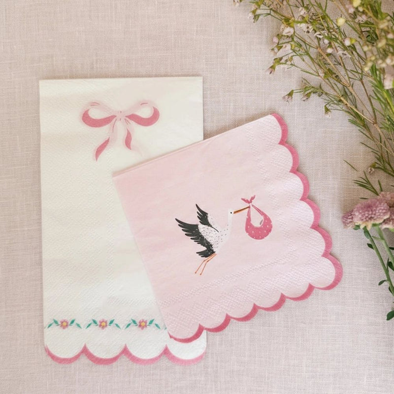 Pink stork napkin paired with a white bow-themed luncheon napkin