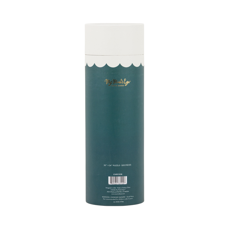 Cozy Christmas puzzle tube styled with other holiday puzzles among greenery and gift boxes