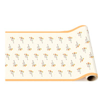 Rolled floral table runner unrolled partway, showing the repeating vintage flower pattern and orange border.