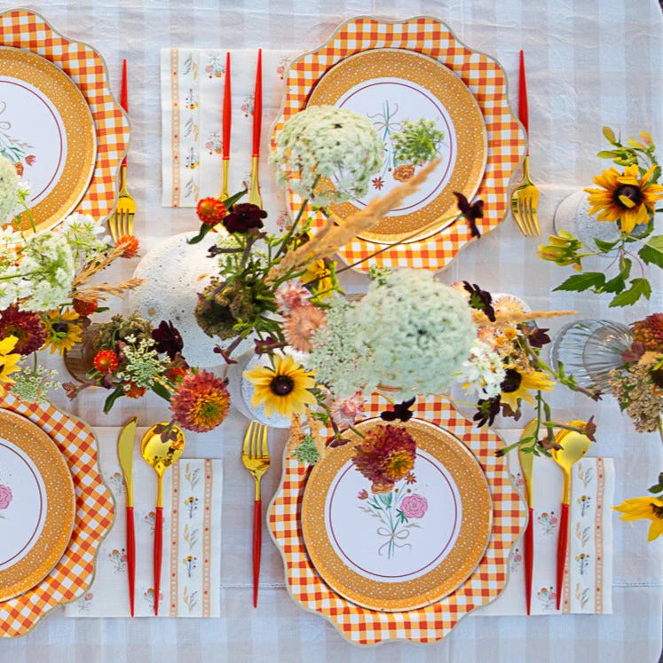 Outdoor fall tablescape with floral lunch napkins, gingham chargers, and wildflower centerpiece.
