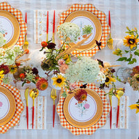 Outdoor fall tablescape with floral lunch napkins, gingham chargers, and wildflower centerpiece.