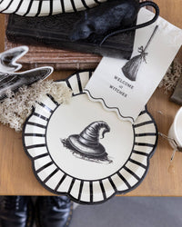 Styled Halloween wooden surface of the paper plates set along with other witch related crafts.
