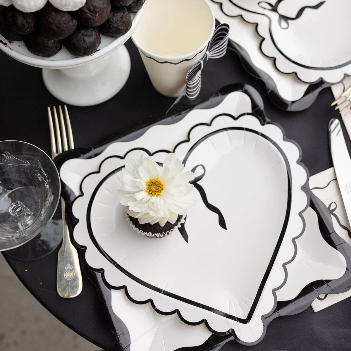 Black and cream heart plates styled on a monochrome Valentine’s table.
