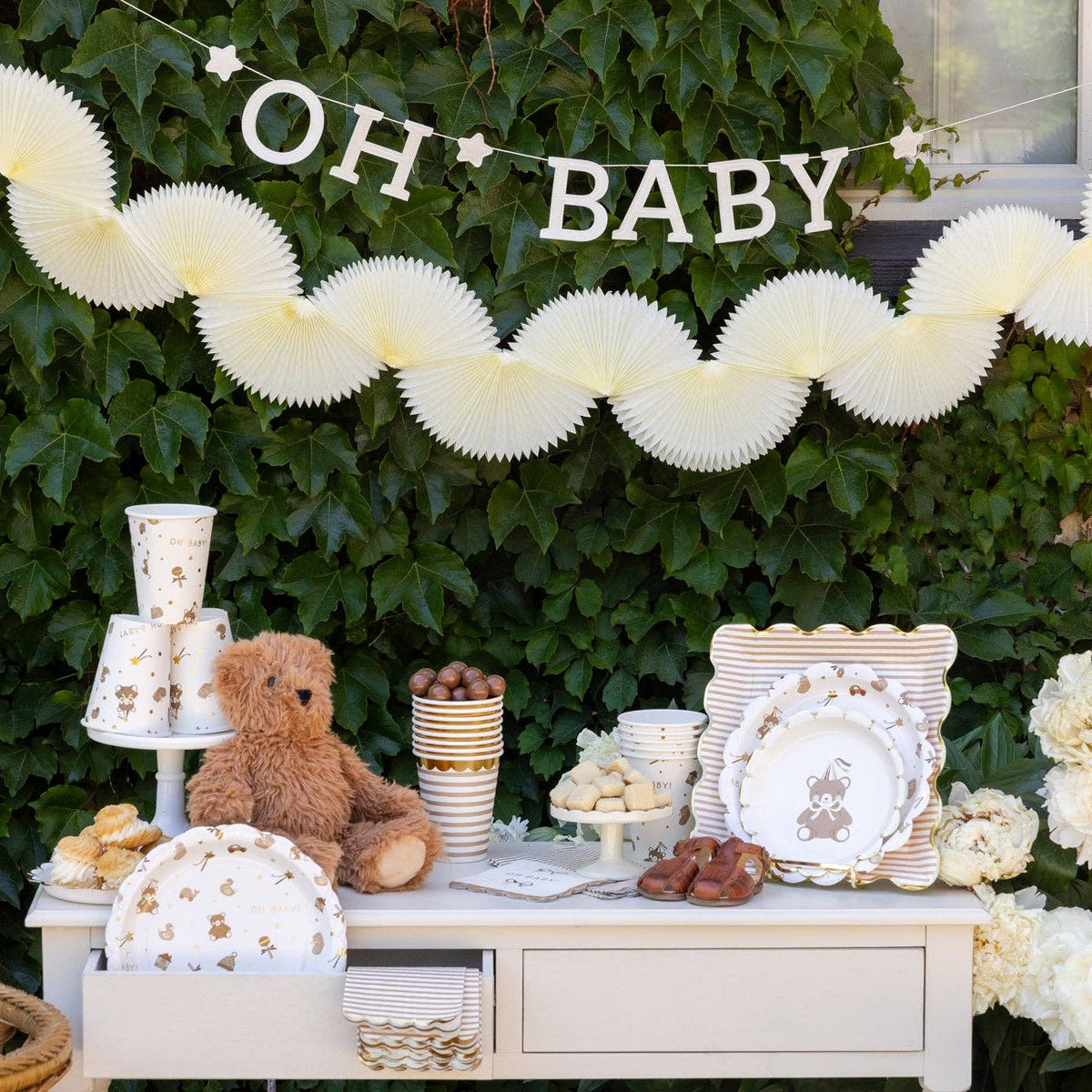 Cream tissue bunting banner styled on baby shower dessert table
