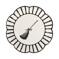 Designed with a classic black and white striped rim, this plate showcases an eye-catching witch broom illustration in the middle.
