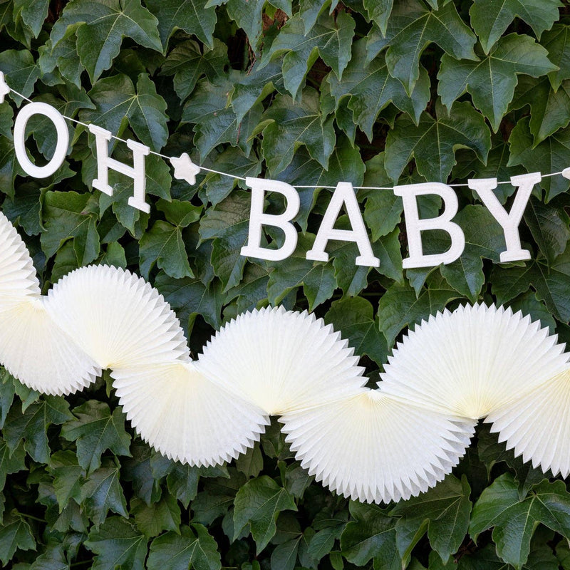 Cream paper fan bunting banner with oh baby sign backdrop
