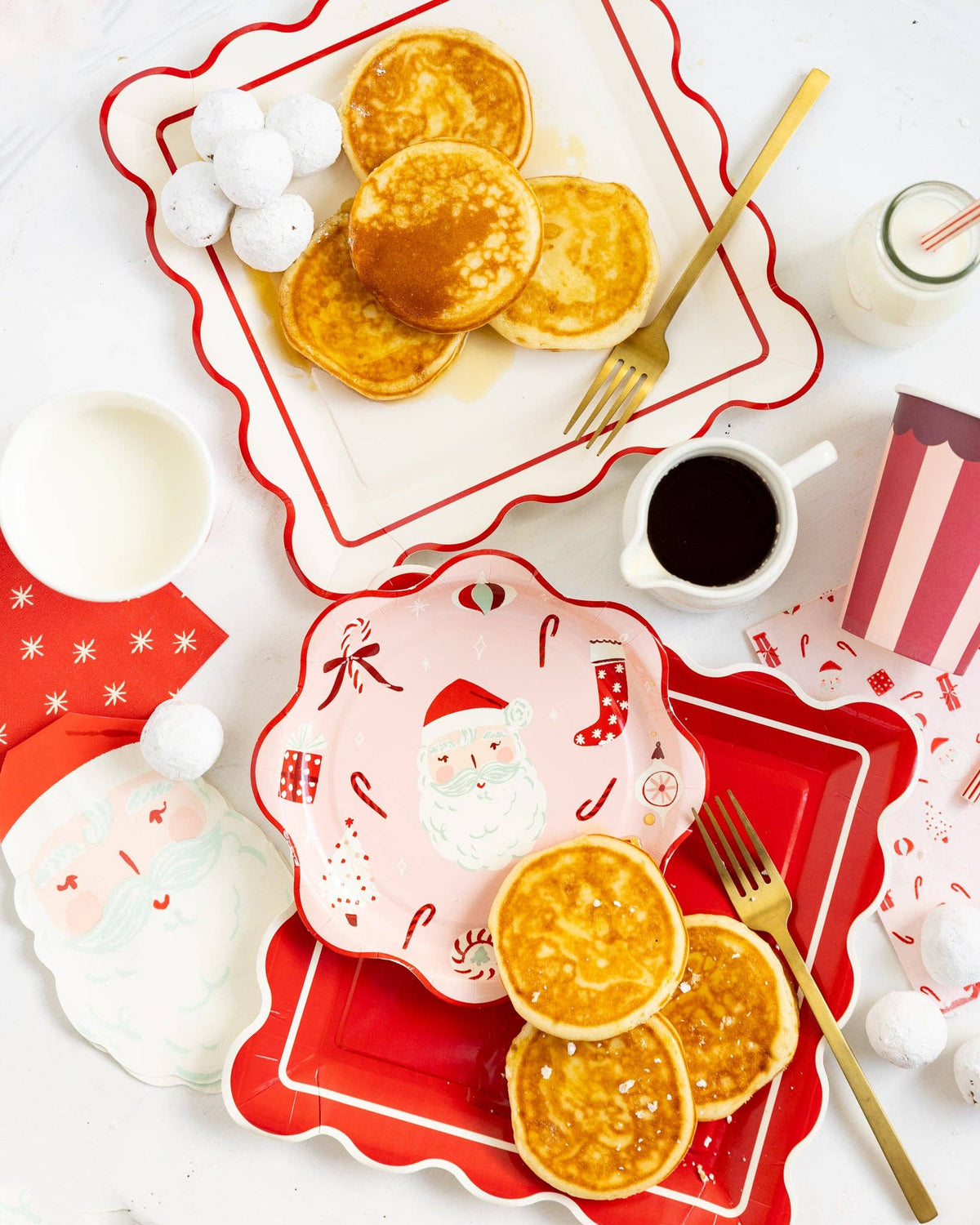 Cream scalloped plate styled on Christmas breakfast table with pancakes and red plates