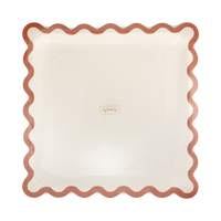 Stack of cream square paper plates showing the rust wavy ric-rac edge, front view.