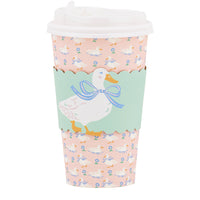 A single 16oz paper to-go cup featuring a pink duckling print, a mint green scalloped sleeve with a duck illustration, and a white plastic lid.