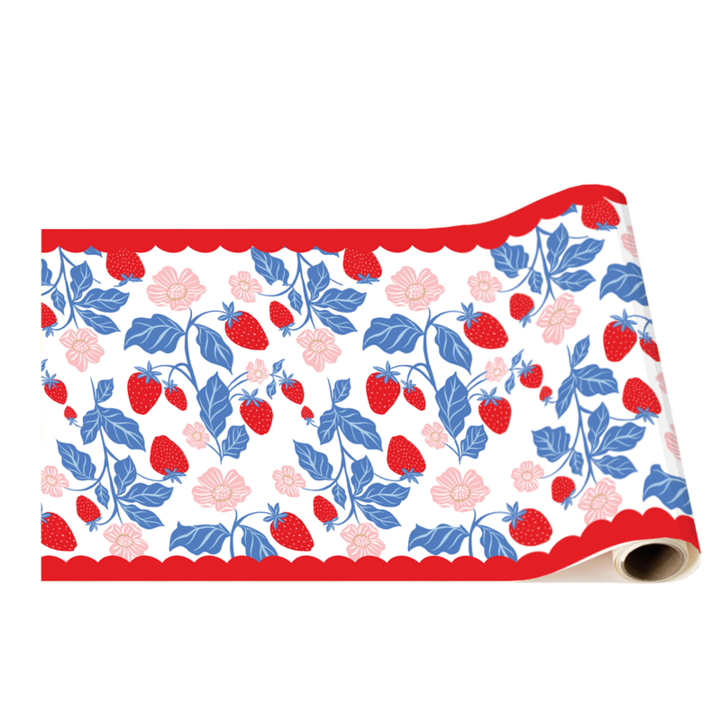 A roll of decorative table runner paper featuring a repeating pattern of red strawberries, blue leaves, and pink flowers bordered by a red scalloped edge.