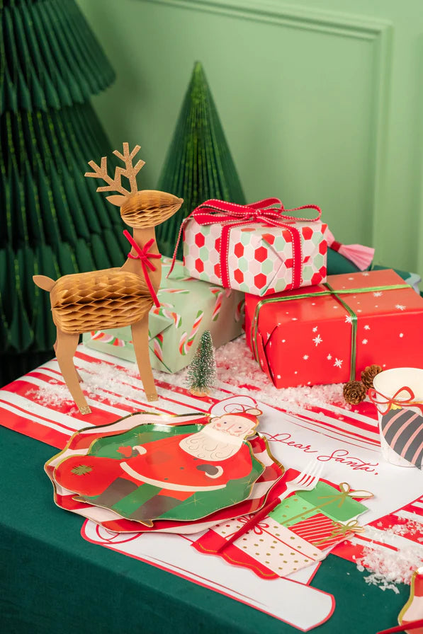 Place setting with Santa plate stacked on scalloped charger over scroll placemat.
