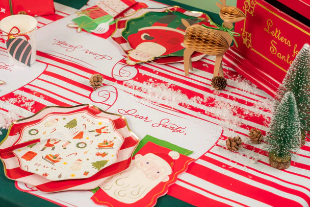 Overhead spread with multiple settings using red striped runners and scroll Christmas placemats.