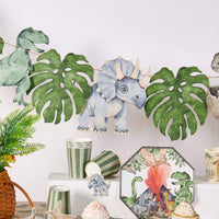 dinosaur birthday banner with leaves above matching decor