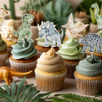 Dinosaur cupcake toppers on frosted cupcakes with green icing
