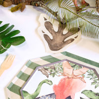 Dinosaur party table setup with footprint napkins and themed plates