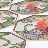 Alt Text: Multiple dinosaur party plates spread out on a white surface