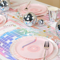 High-energy disco cowboy party table featuring holographic chargers, silver cups, and pastel confetti.