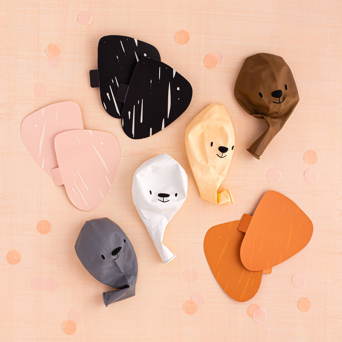 Flat lay of balloon kit components including balloons, paper ears, and accessories