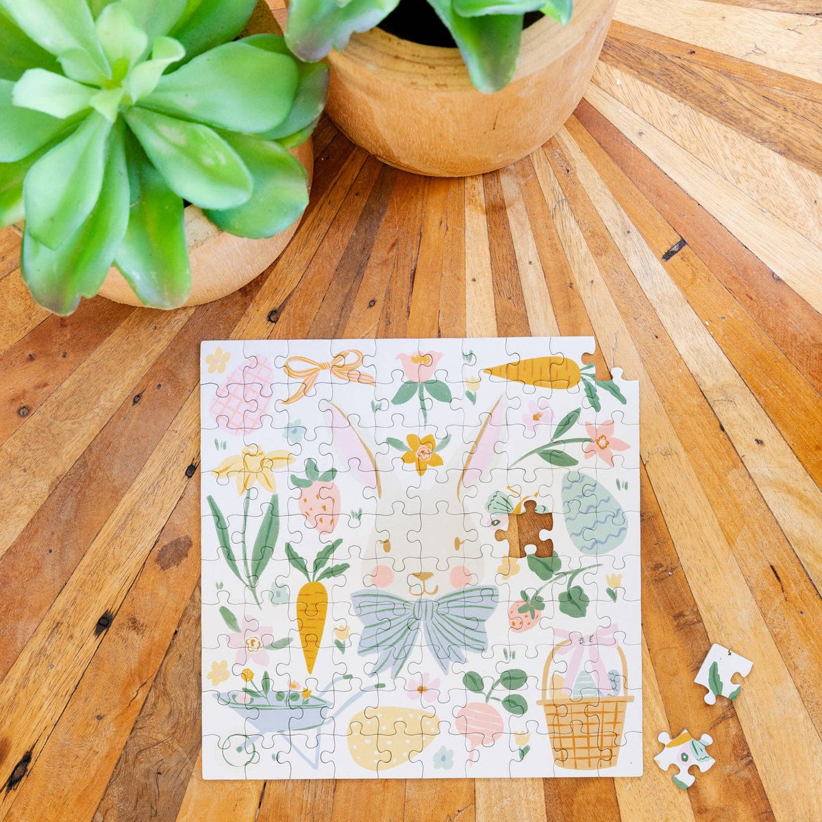 Partially assembled Easter bunny puzzle on wooden table with loose pieces nearby