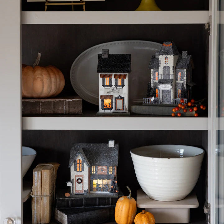 Styled shelf with Eastside Elixirs illuminated apothecary and pumpkins—vintage halloween putz houses display