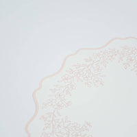Detailed view of the soft scalloped border and botanical sprig pattern