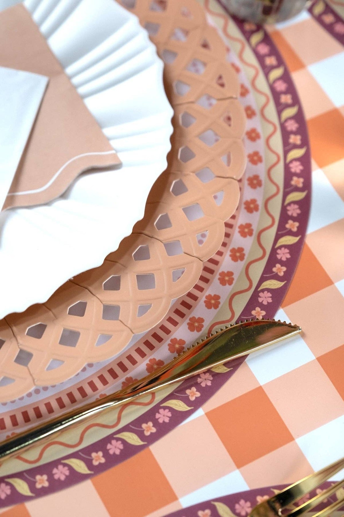 Macro detail highlighting the woven embossed texture along the scalloped rim of the light brown paper plate.