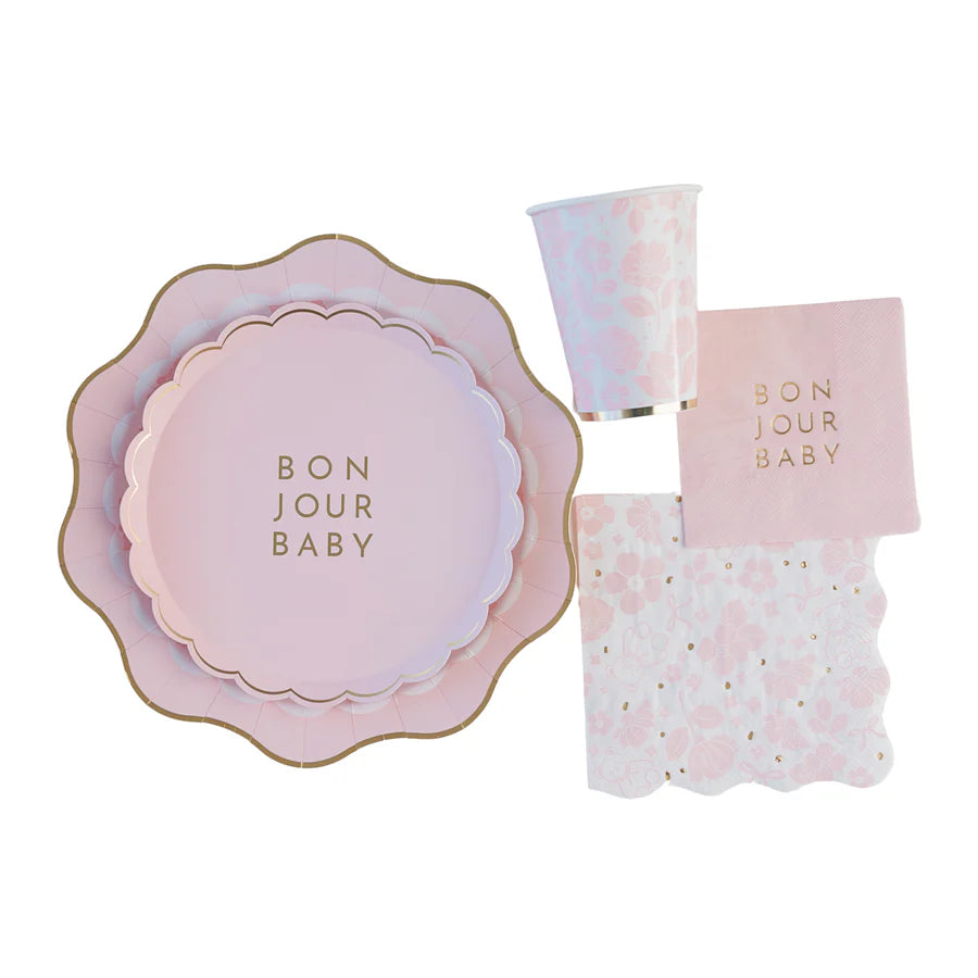 Flat‑lay of coordinating Bonjour Baby party set showing scalloped plates, floral cup and Emma Bear napkins.