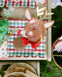 Multicolor gingham square paper plate under a reindeer plate with a gingerbread cookie; reindeer plate, fork, napkins, and piping bag shown separately, not included