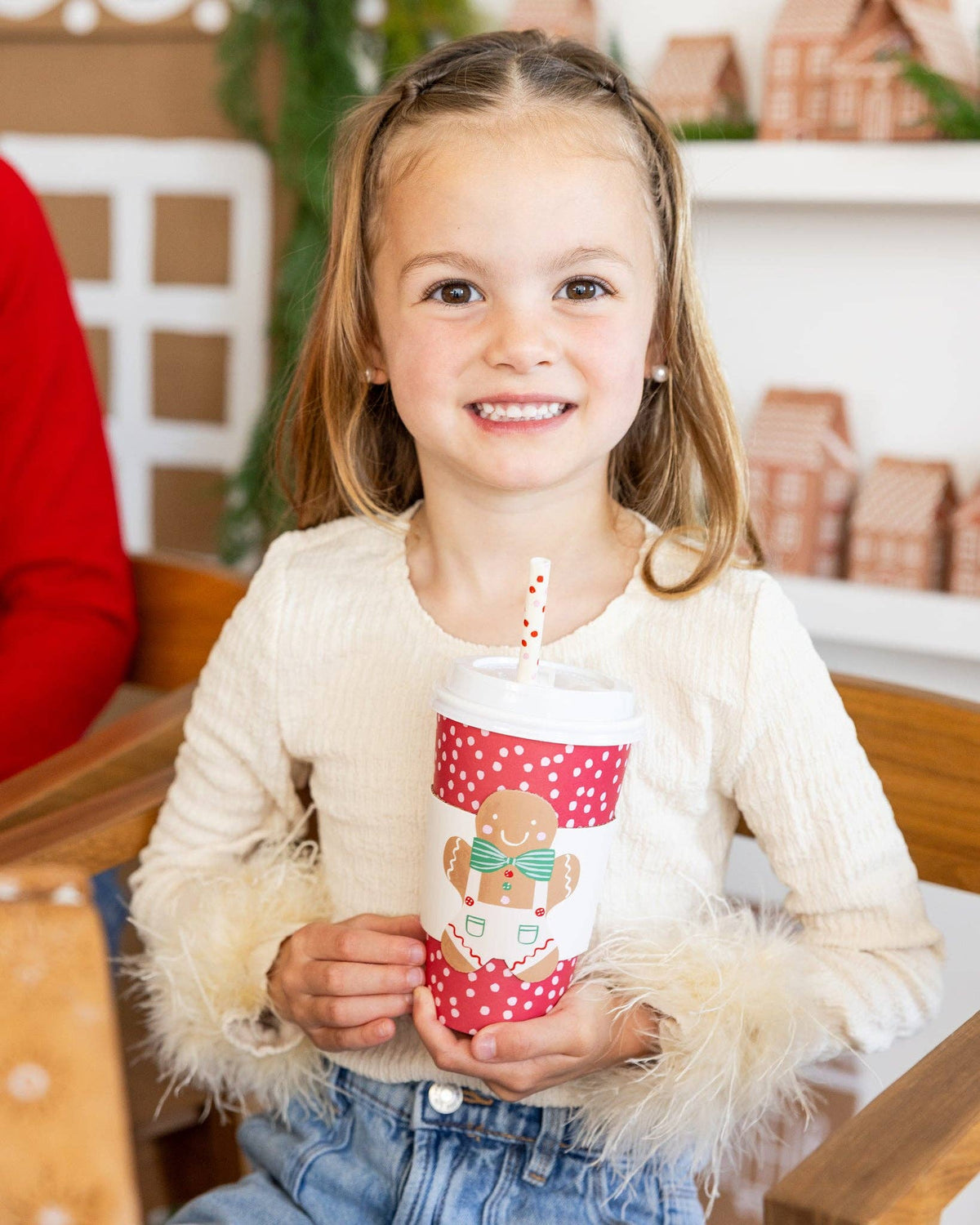 Child smiling with Gingerbread To-Go Cup with straw