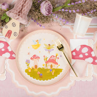 Place setting featuring mushroom cottage scene at center of plate.