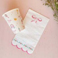Princess paper cup styled next to a scalloped bow napkin