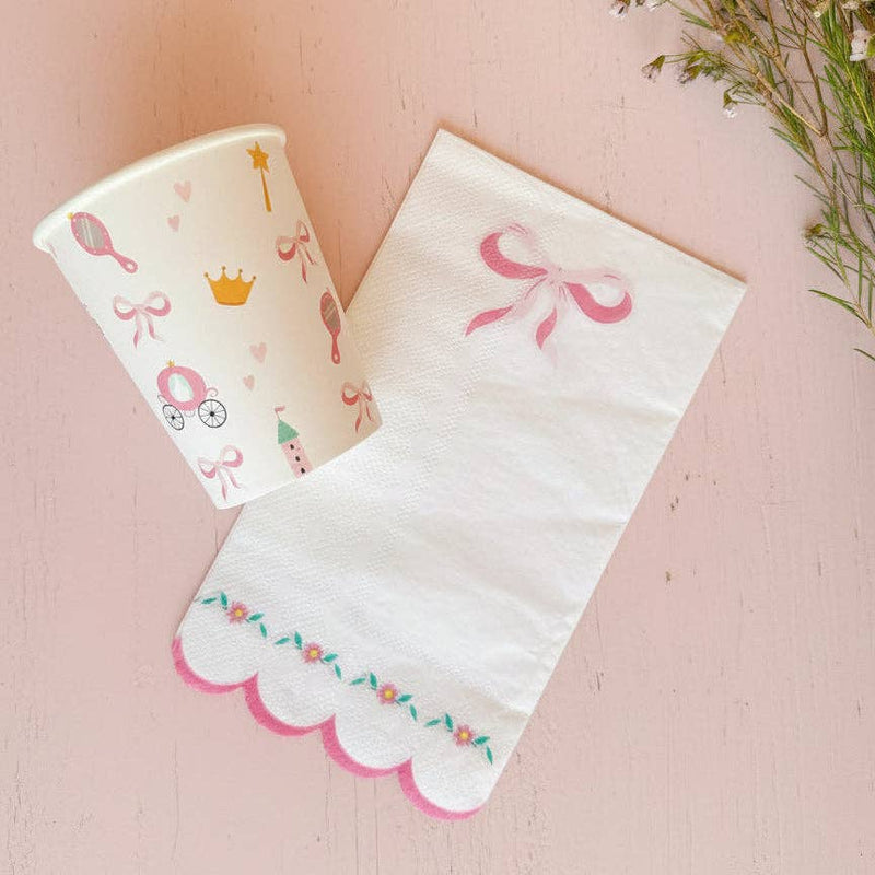 Princess paper cup styled next to a scalloped bow napkin