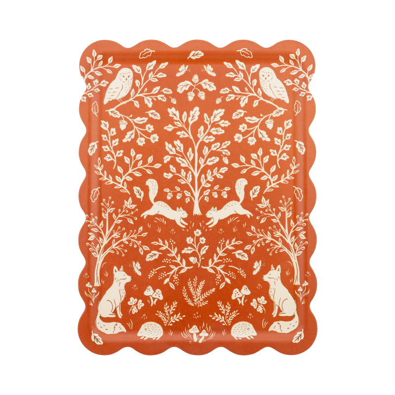 Fall bamboo serving tray in rust and cream with a scalloped edge and folk-art woodland illustration of deer, birds, acorns, and oak leaves, overhead view on white background.