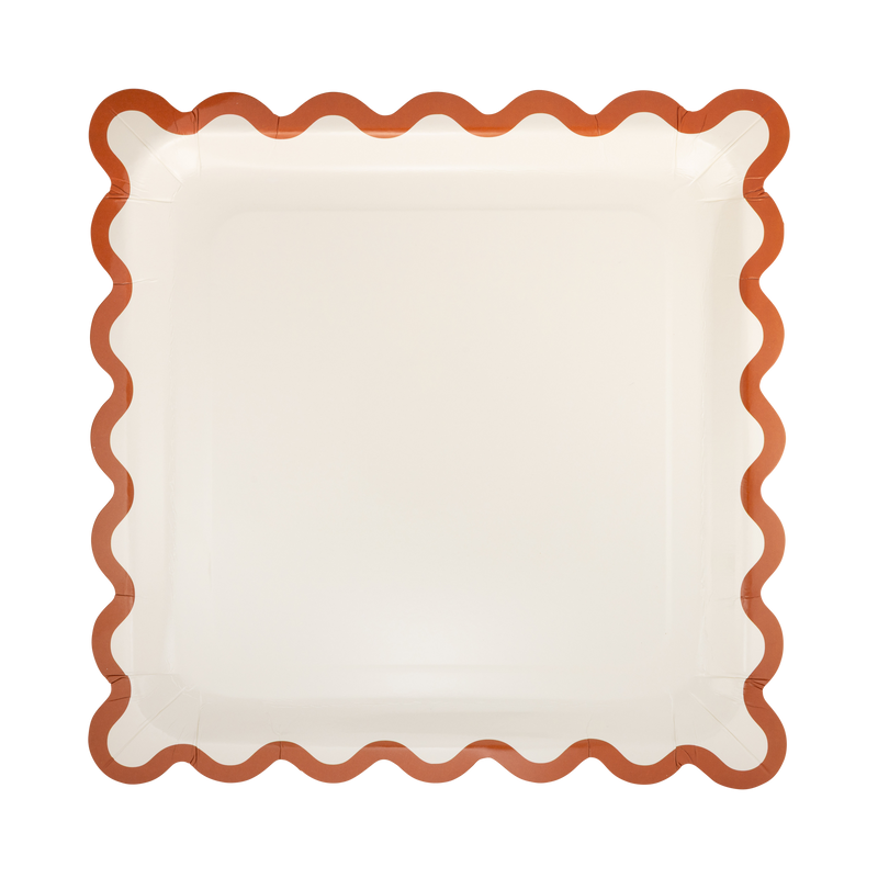 Solid cream fall square paper plate with a rust wavy ric-rac edge, overhead view on gray background.