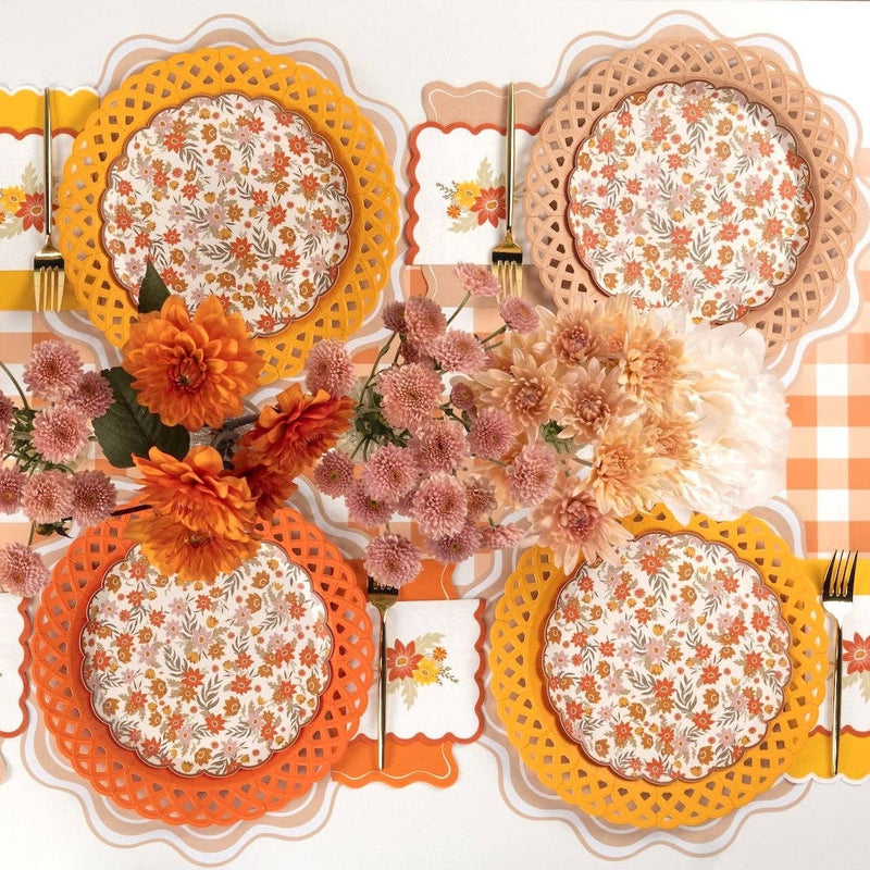 Overhead fall table for four with floral dessert plates on lattice chargers in marigold, tan, and orange
