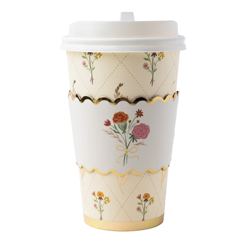 Fall floral coffee cup with a lid, cream with an autumn floral design, gold foil accents, and a gold wavy line, front view on white background.