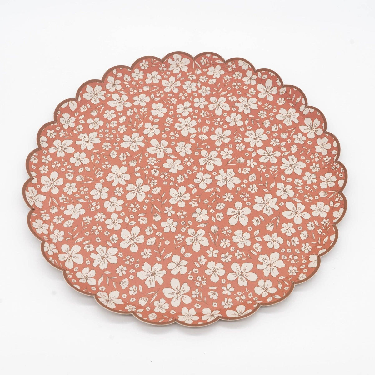 Rust fall floral scalloped paper dinner plate at an angle on white, showing the 10.5 inch round shape