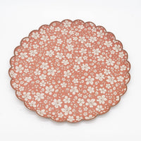 Rust fall floral scalloped paper dinner plate at an angle on white, showing the 10.5 inch round shape