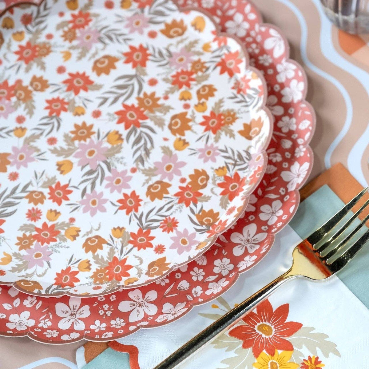 Cream retro floral plate stacked on the rust floral plate showing both designs and the scalloped edges