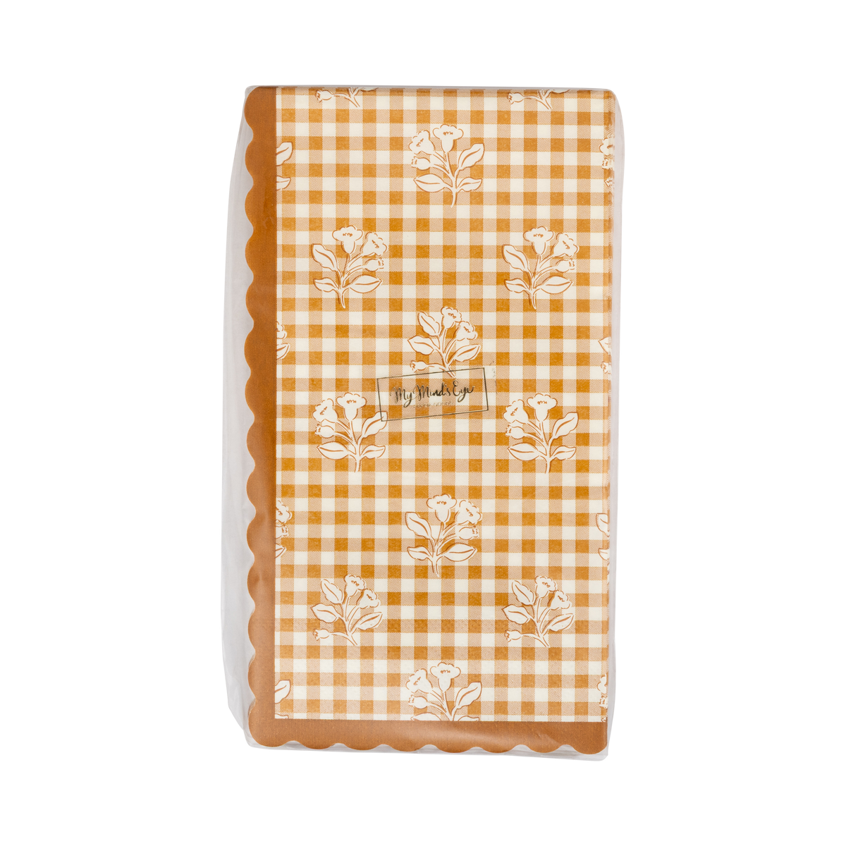 Stack of fall gingham paper dinner napkins showing the orange-cream check pattern and wavy edge, front view.